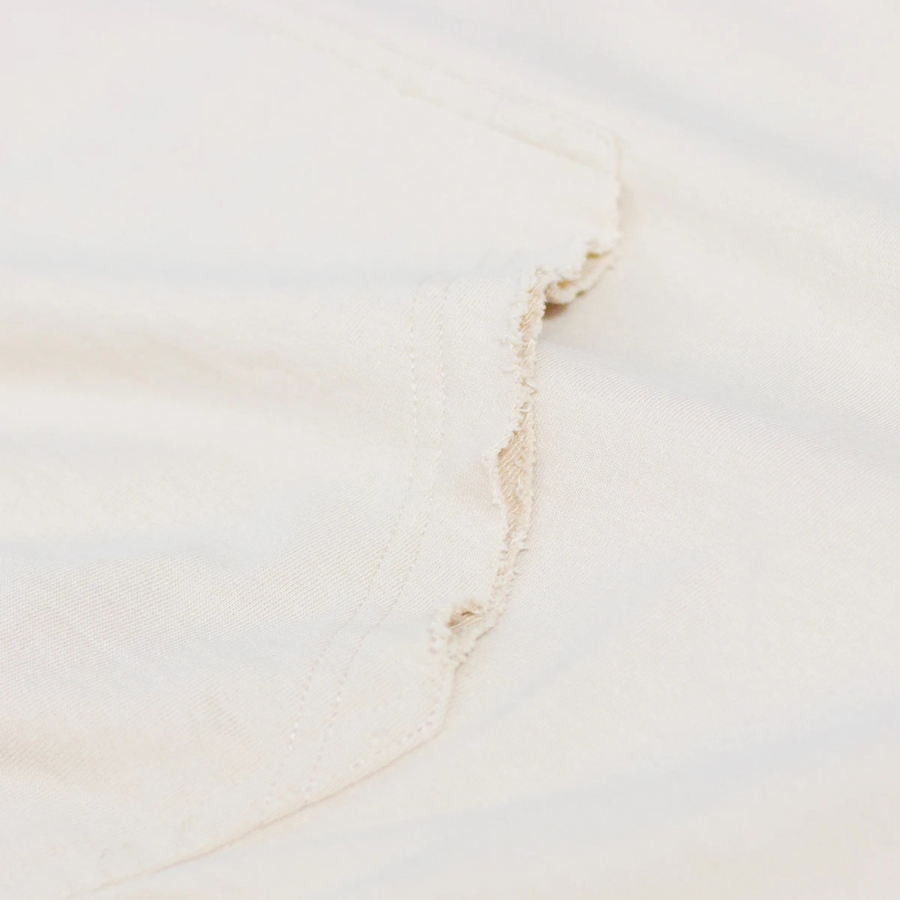 Detalle del bolsillo canguro con costuras desgastadas en sudadera retro.