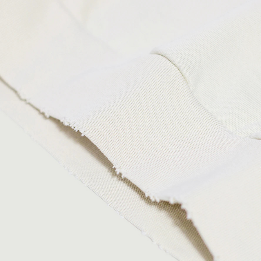 Detalle del bajo de la sudadera retro con acabado deshilachado y tejido grueso.